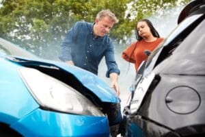 Drivers looking at damage after a car accident in Grand Rapids, Michigan.