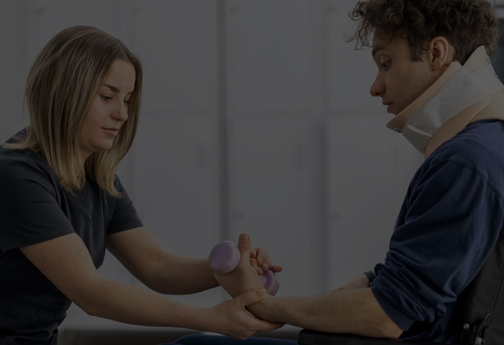 Physical therapist helps a young man in a wheelchair complete rehabilitation exercises.