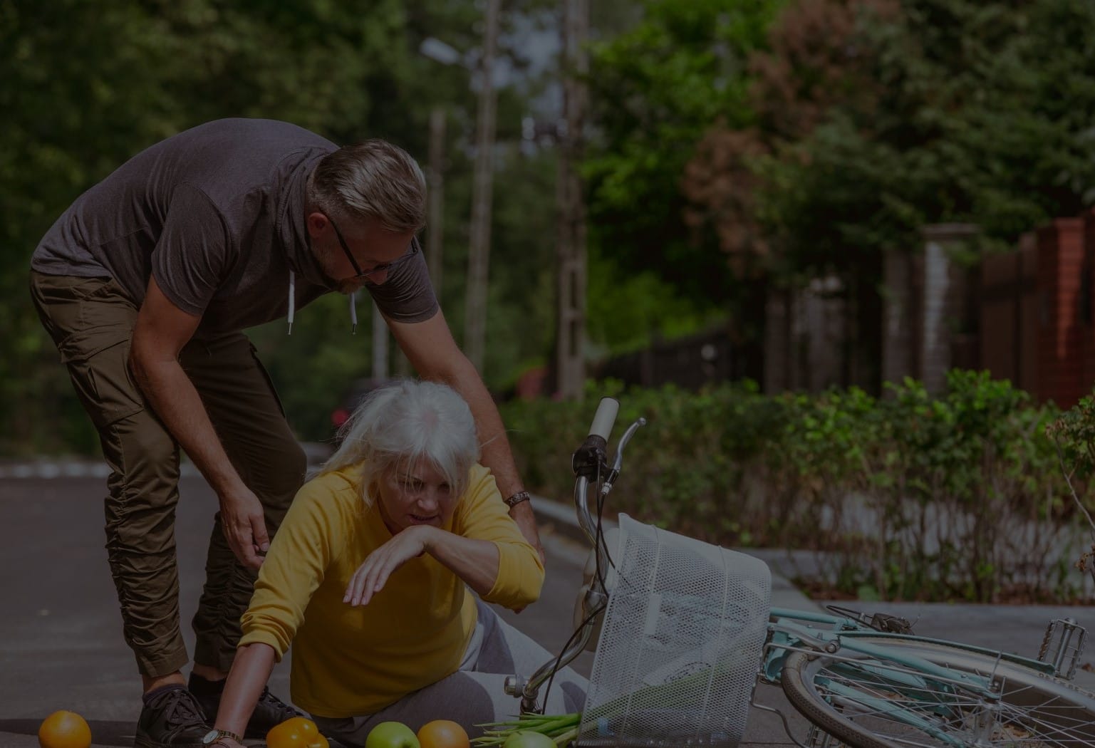 Pedestrian stops to help an older woman up from the ground after bicycle accident in Grand Haven.