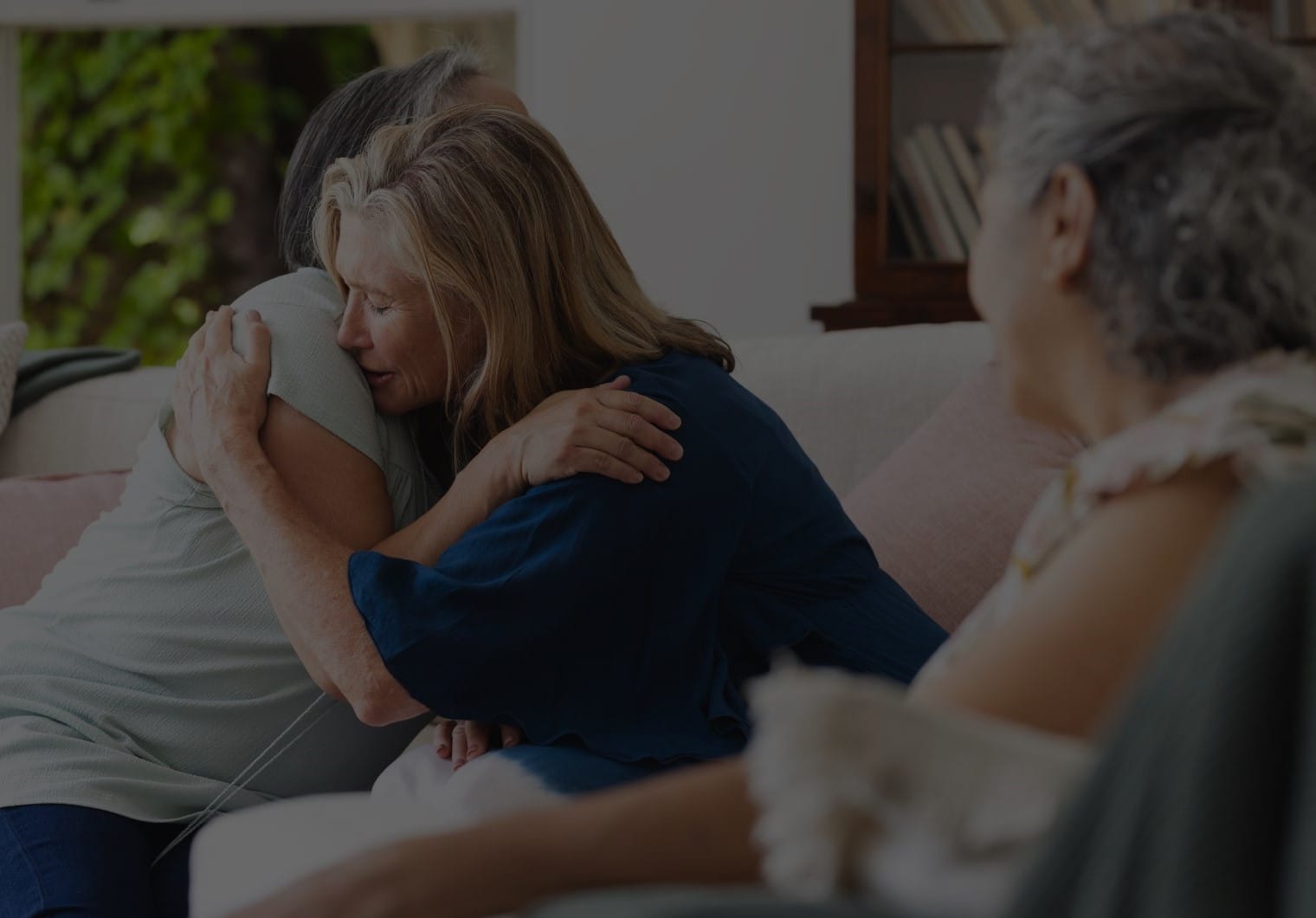 Friends comfort an older woman grieving after a wrongful death in Grand Haven.