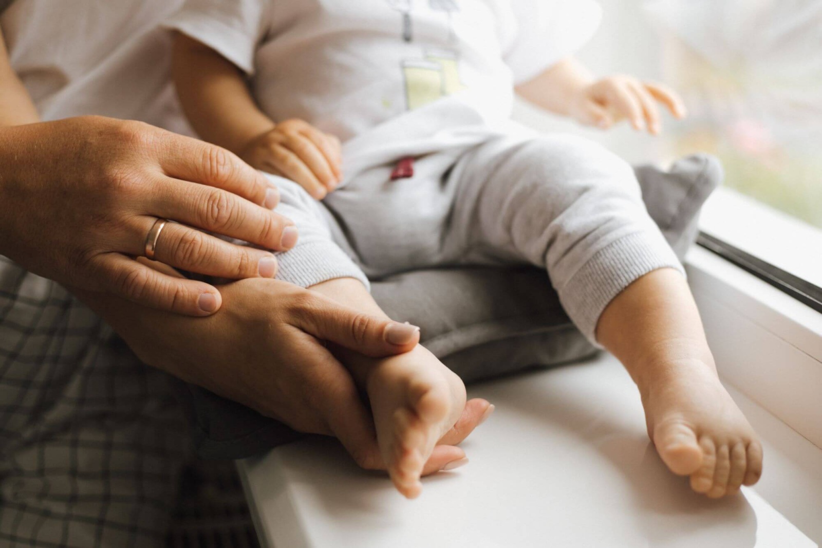 Closeup of mom holding infant's leg and foot after birth injury.