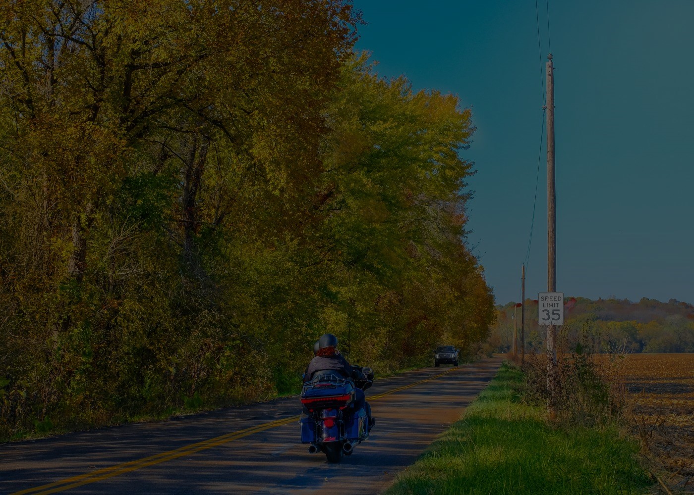 Couple rides motorcycle on two-lane road in West Michigan