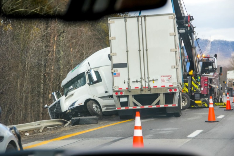 Jackknifed tractor-trailer with tow truck after accident on Michigan highway