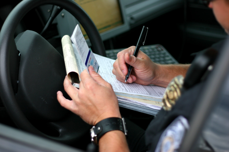 A police officer filling out a report in his car after an accident.